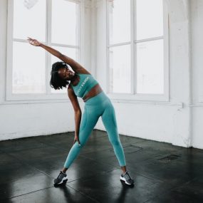 a woman in a blue sports bra top and leggings doing a yoga pose